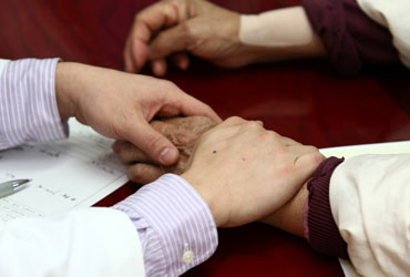 목동자생한방병원 자생치료의 특징-환자 손을 잡아 건강상태를 체크 하고 있는 의사의 모습